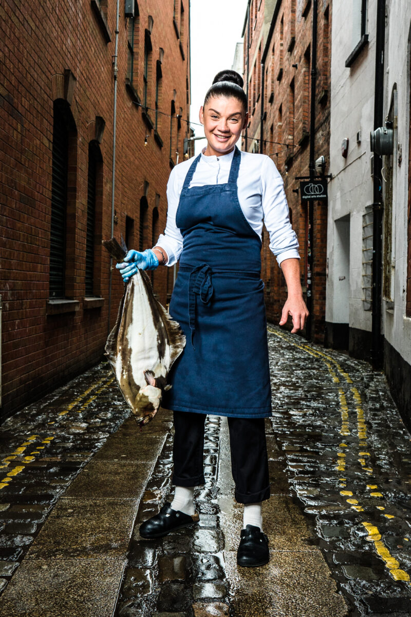 Chef Lottie Noren of Beau Restaurant Belfast. Photography: Elaine Hill, Belfast, Northern Ireland. - Chef Lottie Noren with halibut on streets of Belfast Cathedral Quarter